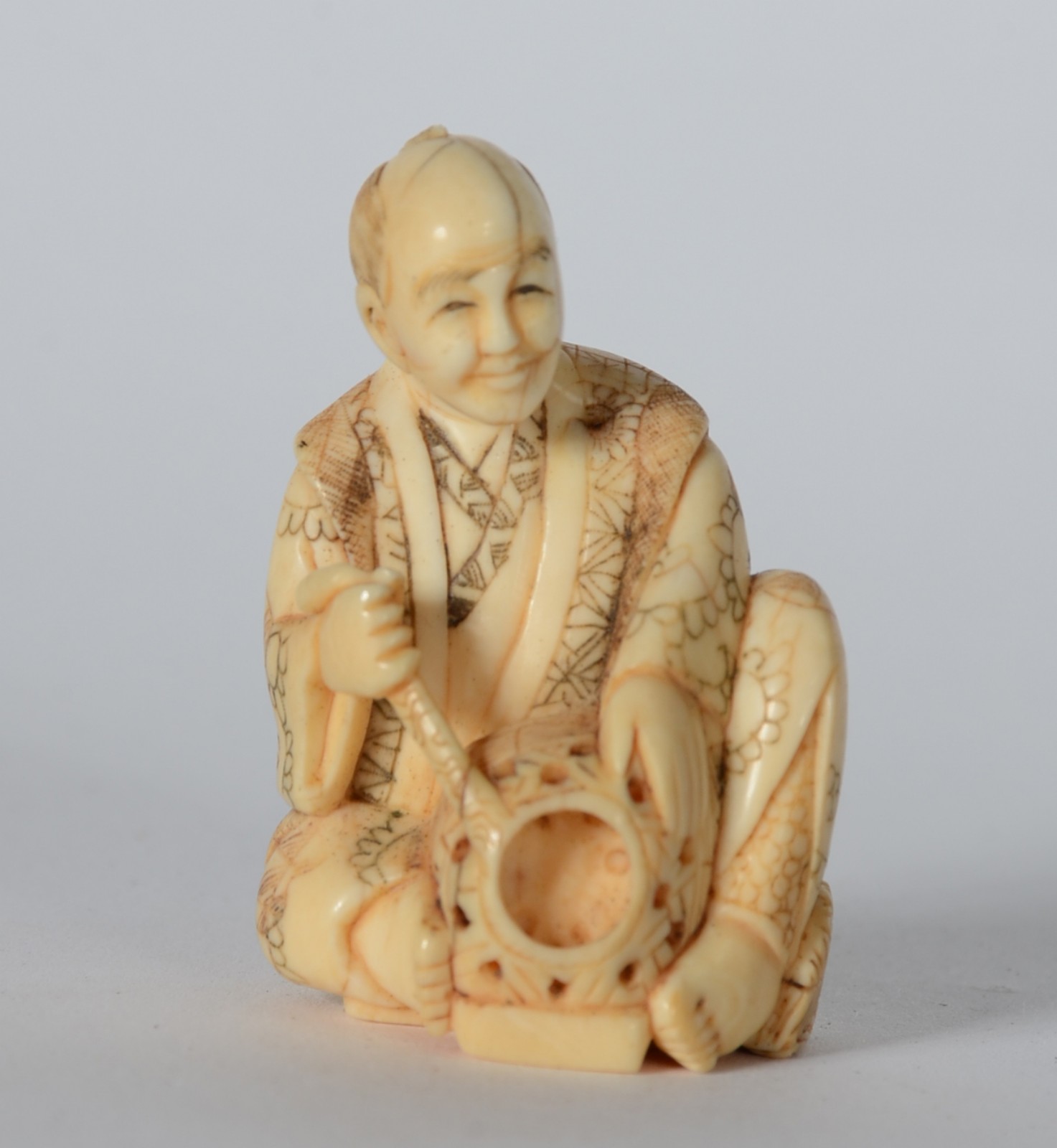 Netsuke de marfim representando figura com instrumento, assinado. - foto 1 de 5