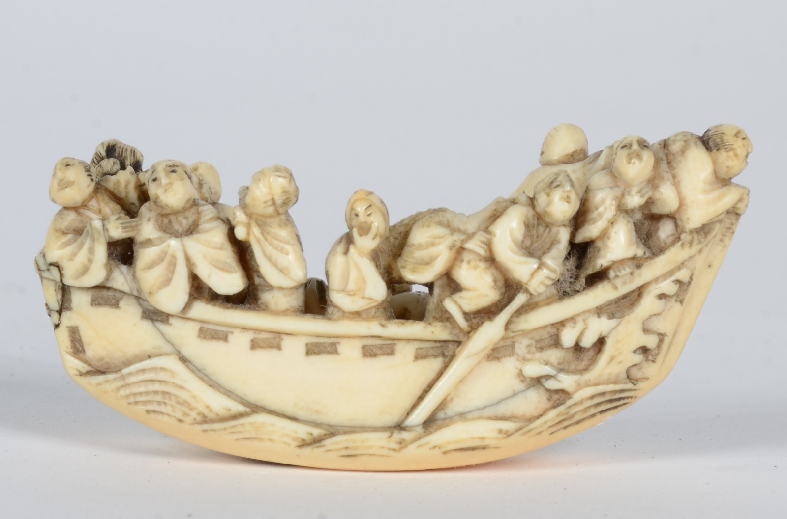 Netsuke de marfim representando barca com figuras, assinado. - foto 1 de 5