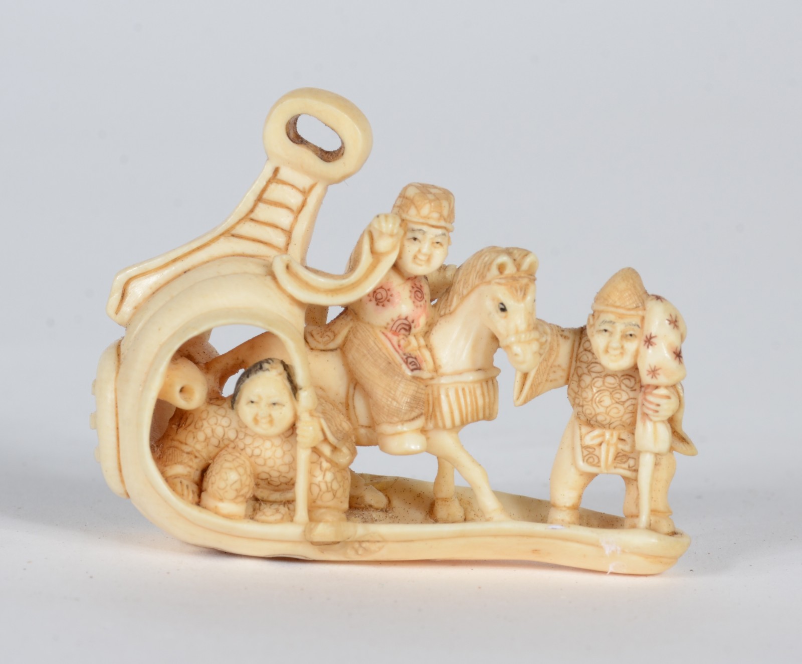 Netsuke de marfim representando figura a cavalo ladeado por figura... - foto 1 de 6