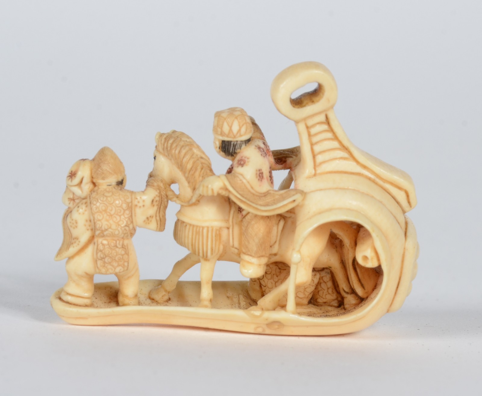 Netsuke de marfim representando figura a cavalo ladeado por figura... - foto 2 de 6