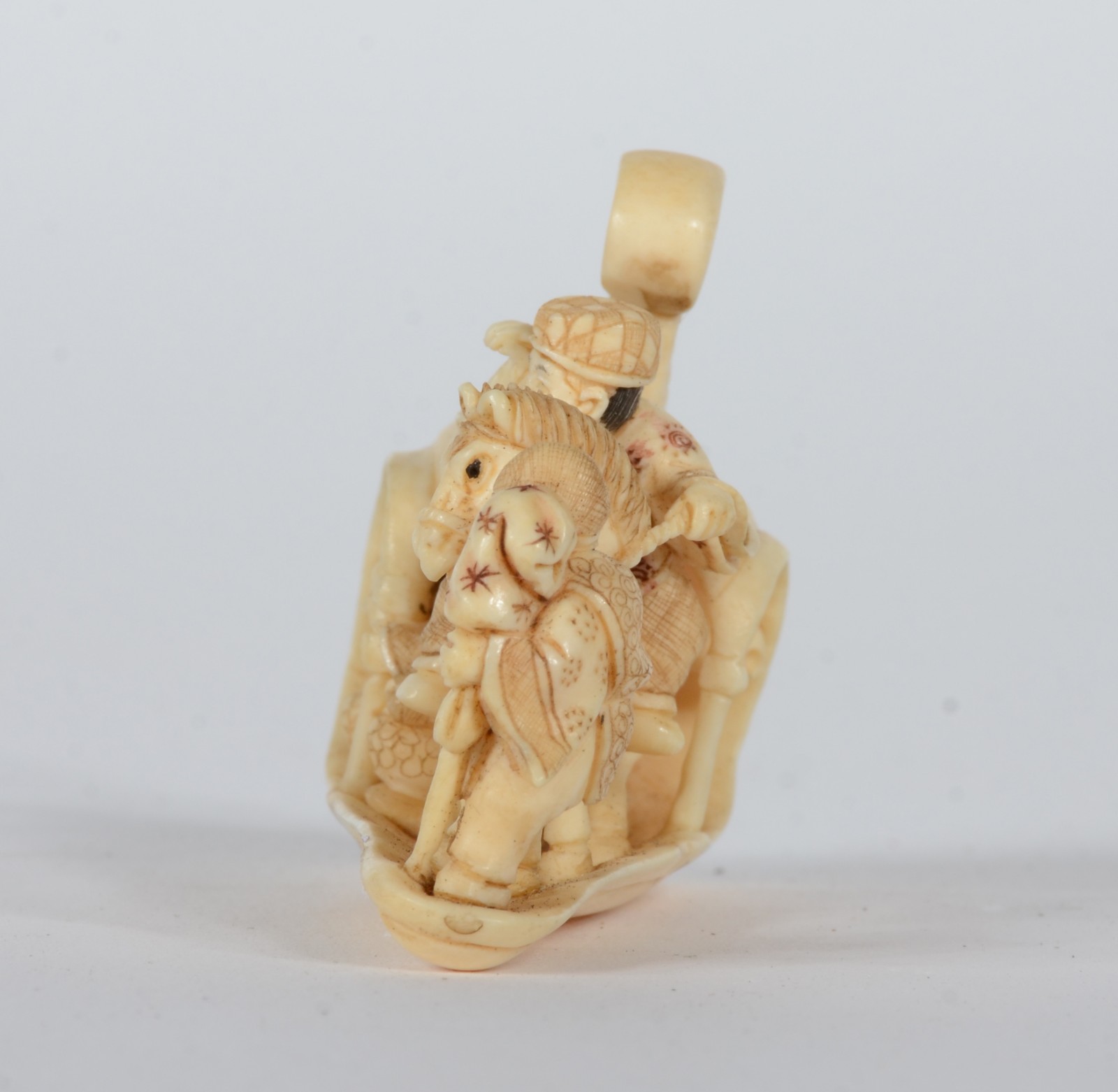 Netsuke de marfim representando figura a cavalo ladeado por figura... - foto 3 de 6