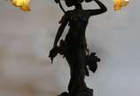 Lucien Alliot (1877-1967),  - Luminária de mesa para 2 luzes de bronze patinado representando Figura feminina e ramos de folhas. Assinado. Base de madeira. Mangas de vidro branco f