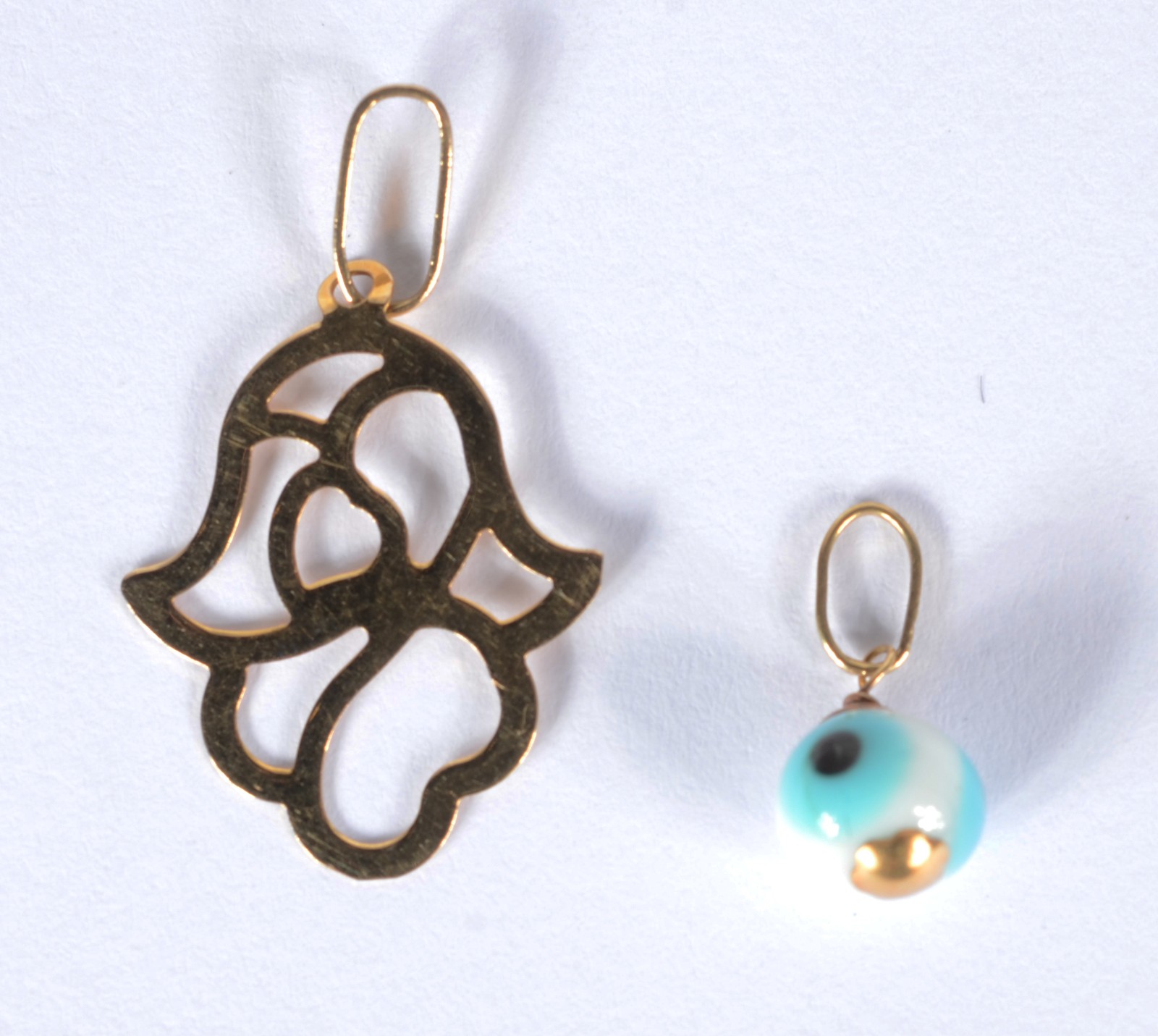Dois pendentes de ouro 18 k., sendo uma mão de Hamsa com vazados e... - foto 2 de 2