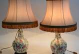 Par de abatjoures de porcelana oriental com flo... - Par de abatjoures de porcelana oriental com flores em policromia, bases de madeira. Acompanham cúpulas.