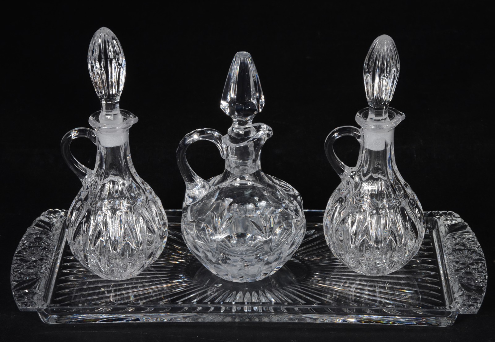 Quatro peças diversas de cristal europeu lapidado, sendo: 3 galhetas... - foto 1 de 6