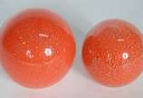 Dois pesos de papel na forma de esferas de vidr... - Dois pesos de papel na forma de esferas de vidro decorativo na cor laranja com pó de ouro.
