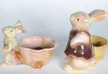 Duas esculturas de porcelana policromada repres... - Duas esculturas de porcelana policromada representando coelhos com cestos.