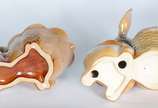 Duas esculturas de porcelana policromada repres... - Duas esculturas de porcelana policromada representando coelhos com cestos.