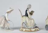 Três estatuetas diversas de porcelana, sendo um... - Três estatuetas diversas de porcelana, sendo uma italiana representando figura feminina "La Traviata", menina com bambolê de porcelana espanhola...