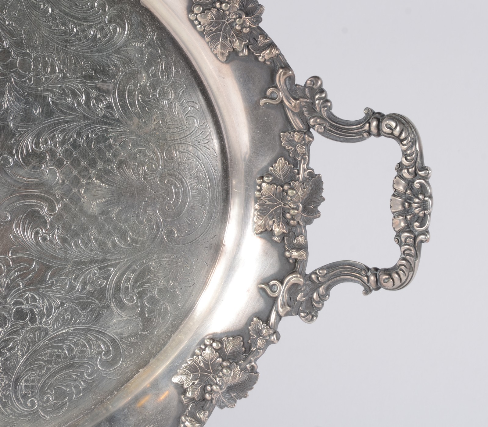 Bandeja com alças de metal prateado, fundo cinzelado com guirlandas e... - foto 2 de 3