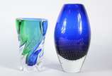 Dois vasos de vidro decorativo, sendo um azul e... - Dois vasos de vidro decorativo, sendo um azul e verde e outro azul com pequenas bolhas internas (batida na base).