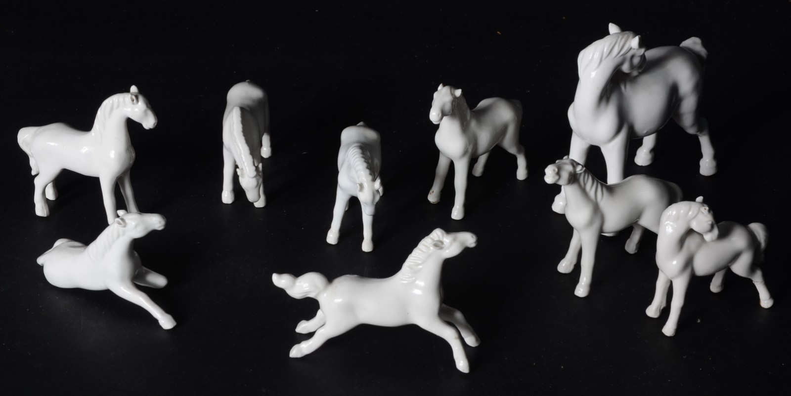 Conjunto com 9 pequenos cavalos de porcelana branca (um com a perna... - foto 1 de 5
