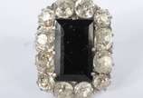 Anel de platina com pedra central ônix e brilha... - Anel de platina com pedra central ônix e brilhantes de aproximadamente 3 kilates. Aro 14. (Por motivos de segurança a peça não se encontra na lo...
