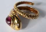 Anel de ouro 18 k., na forma de cobra com peque... - Anel de ouro 18 k., na forma de cobra com pequenos brilhantes nos olhos e pedra oval na cor vermelha. Aro 9. (Por motivos de segurança a peça nã...