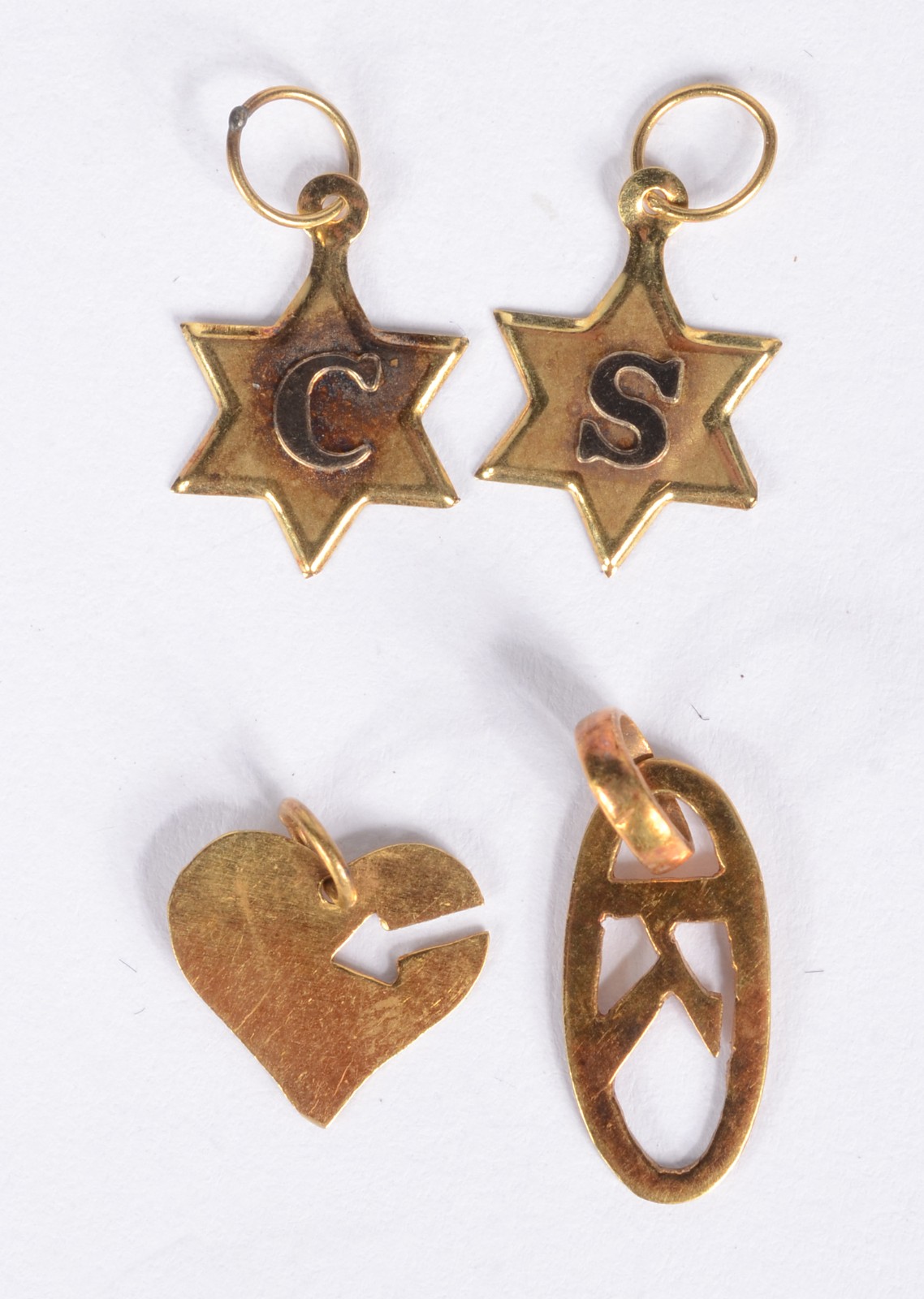 Quatro pendentes de ouro 18 k., sendo duas estrelas com as letras "S"... - foto 1 de 2