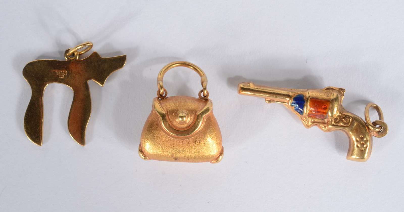Três pendentes de ouro 18k., sendo uma bolsa, cachorro estilizado e... - foto 2 de 3