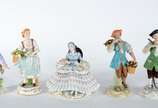 Cinco esculturas de porcelana policromada, send... - Cinco esculturas de porcelana policromada, sendo uma figura de nobre, tres camponeses e dama sentada com saia de renda, de diversas procedências.