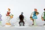 Cinco esculturas de porcelana policromada, send... - Cinco esculturas de porcelana policromada, sendo uma figura de nobre, tres camponeses e dama sentada com saia de renda, de diversas procedências.