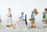 Cinco esculturas de porcelana policromada, send... - Cinco esculturas de porcelana policromada, sendo uma figura de nobre, tres camponeses e dama sentada com saia de renda, de diversas procedências.