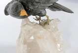 Pássaro de pedra sobre bloco de cristal bruto. ... - Pássaro de pedra sobre bloco de cristal bruto. (Furos do encaixe da pedra diferentes dos que tem nas patas da ave).