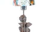 Luminária de petit bronze, base com figura de a... - Luminária de petit bronze, base com figura de anjo com pequena pomba nas mãos,  manga de vidro mesclado em diversos tons.