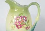 VILLEROY & BOCH,  - Gomil com bacia de porcelana alemã Villeroy & Boch decorado com flores em policromia sobre fundo verde degradé. Fundo do gomil com fio de cabelo. Baci