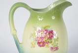 VILLEROY & BOCH,  - Gomil com bacia de porcelana alemã Villeroy & Boch decorado com flores em policromia sobre fundo verde degradé. Fundo do gomil com fio de cabelo. Baci