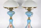 Par de abatjoures de porcelana na cor azul cele... - Par de abatjoures de porcelana na cor azul celeste decorados com cenas românticas em policromia, detalhes em metal dourado, cúpula de vidro leit...