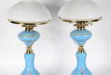 Par de abatjoures de porcelana na cor azul cele... - Par de abatjoures de porcelana na cor azul celeste decorados com cenas românticas em policromia, detalhes em metal dourado, cúpula de vidro leit...