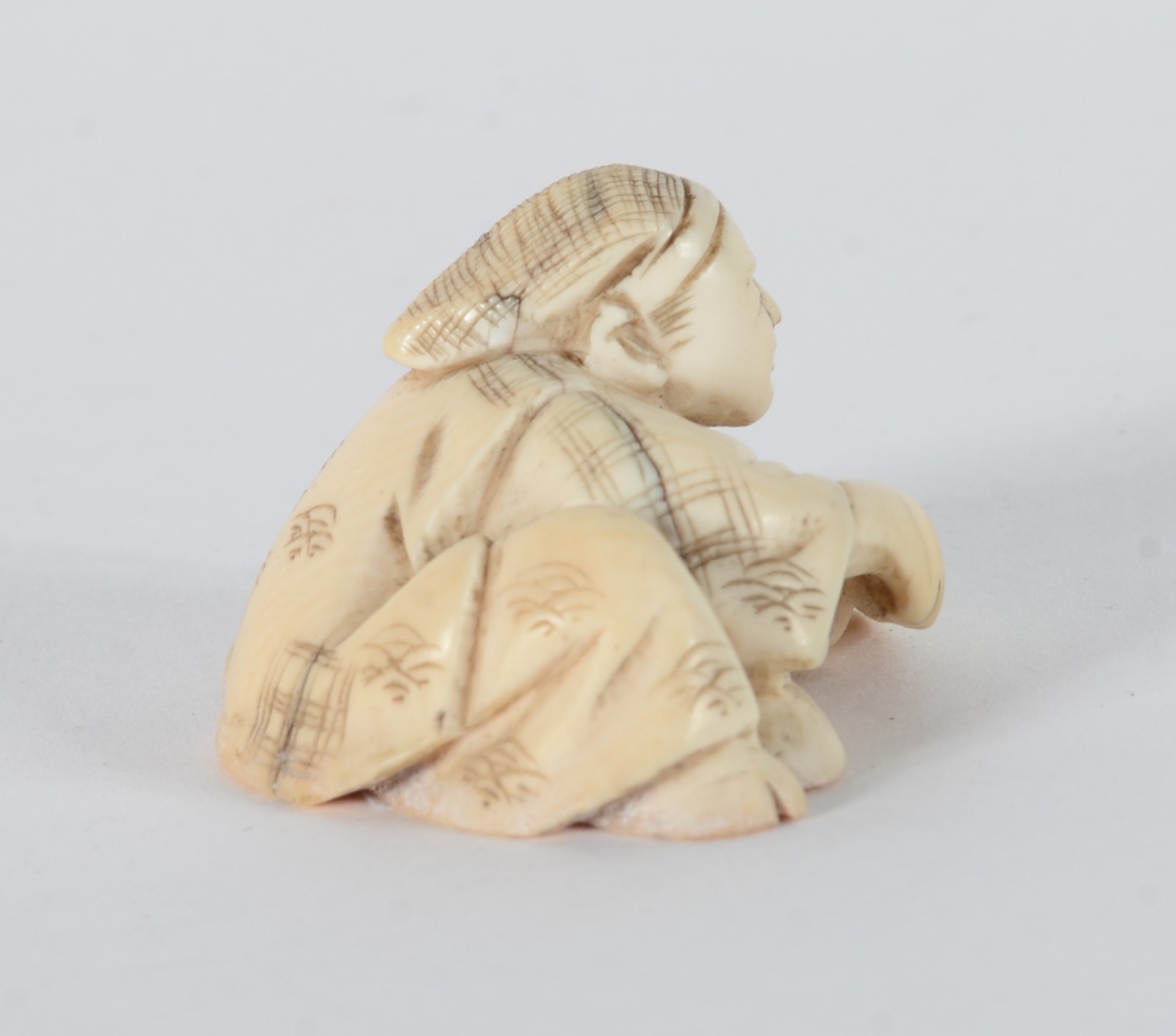 Netsuke de marfim representando figura masculina com faca e peixe... - foto 2 de 5