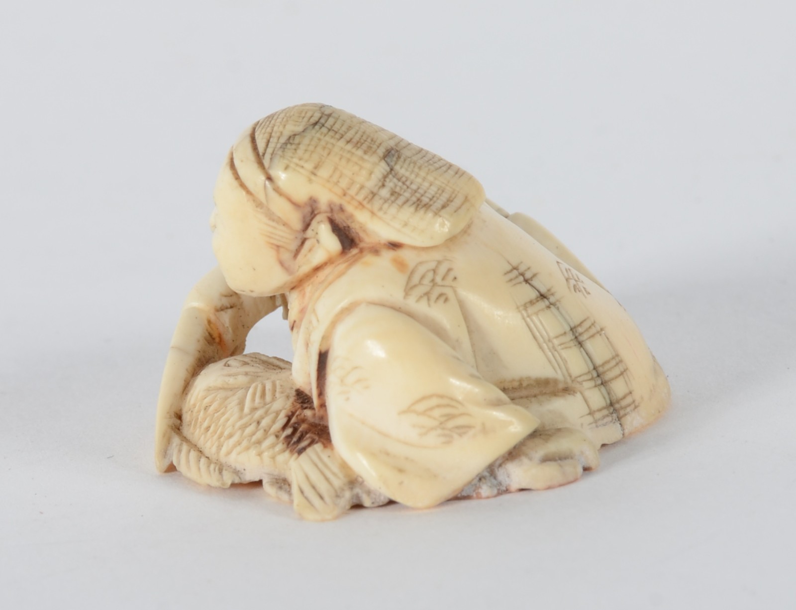 Netsuke de marfim representando figura masculina com faca e peixe... - foto 3 de 5