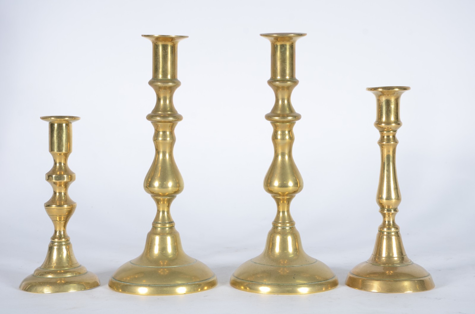 Quatro castiçais de bronze, modelos diversos. - foto 1 de 6