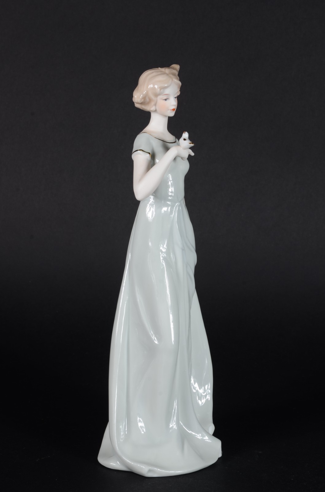 Estatueta de porcelana policromada representando dama com pássaro. - foto 1 de 7
