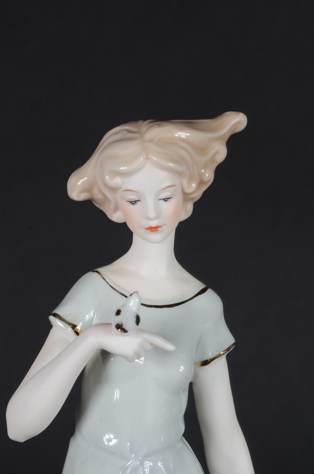 Estatueta de porcelana policromada representando dama com pássaro. - foto 2 de 7