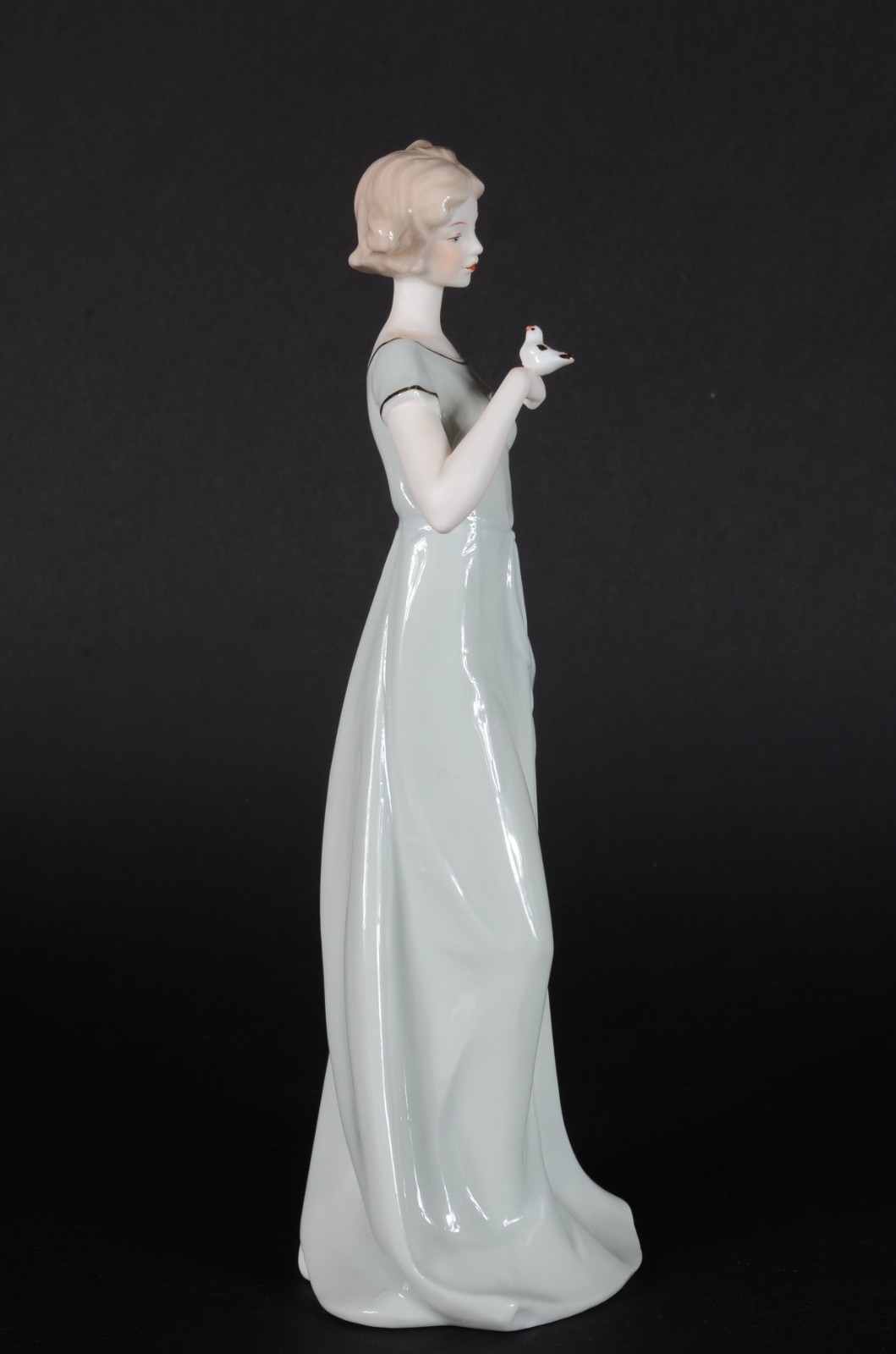 Estatueta de porcelana policromada representando dama com pássaro. - foto 4 de 7