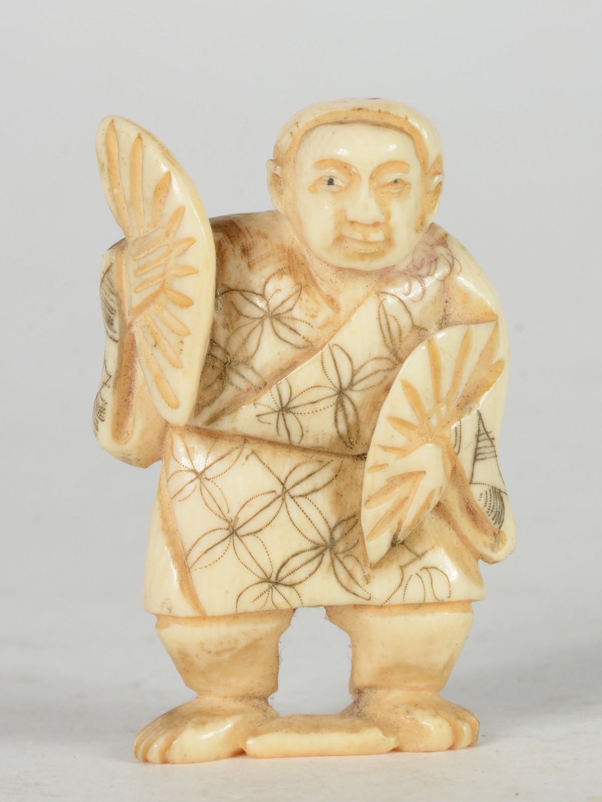 Netsuke de marfim representando figura masculina com leque. - foto 1 de 5