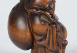 Netsuke de madeira representando buda com cesto. - Netsuke de madeira representando buda com cesto.