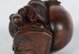 Netsuke de madeira representando buda com cesto. - Netsuke de madeira representando buda com cesto.