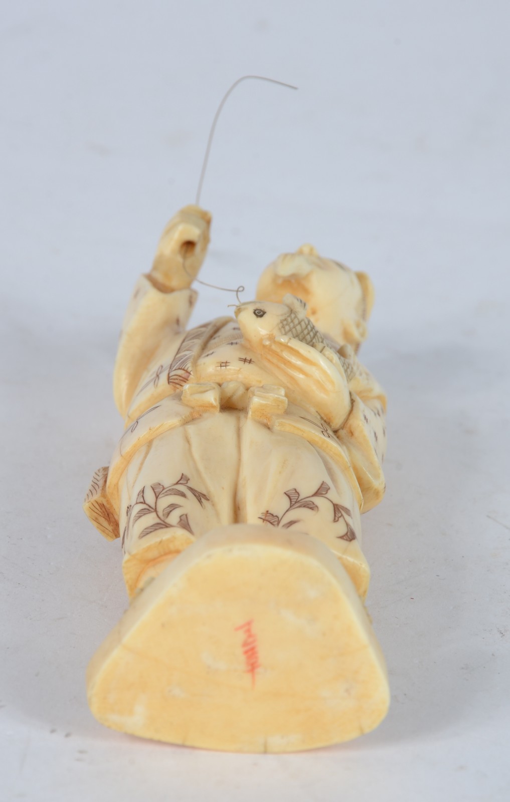 Escultura de marfim representando figura masculina com anzol e peixe. - foto 5 de 5
