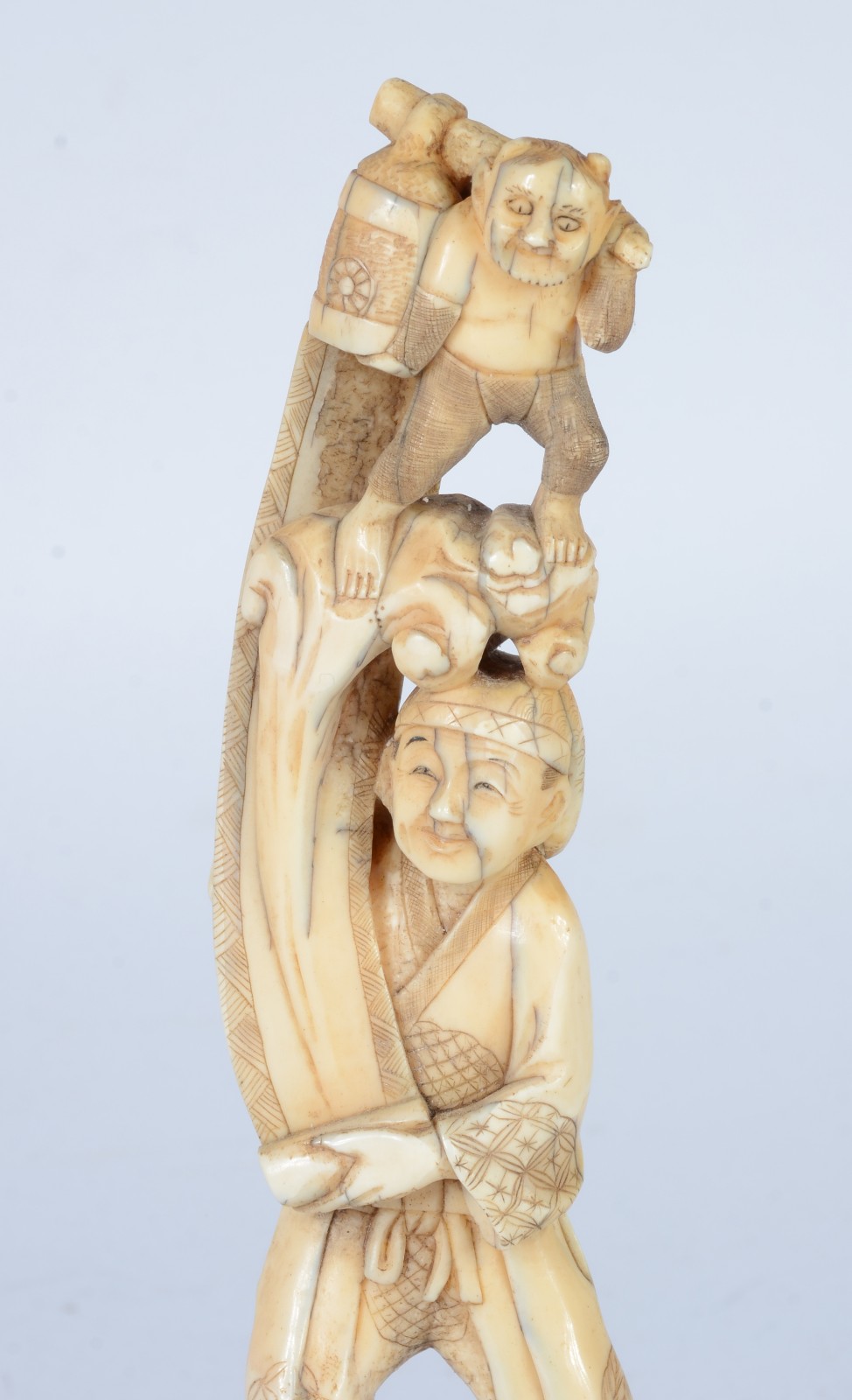 Escultura de marfim representando figura masculina segurando "homem". - foto 2 de 7