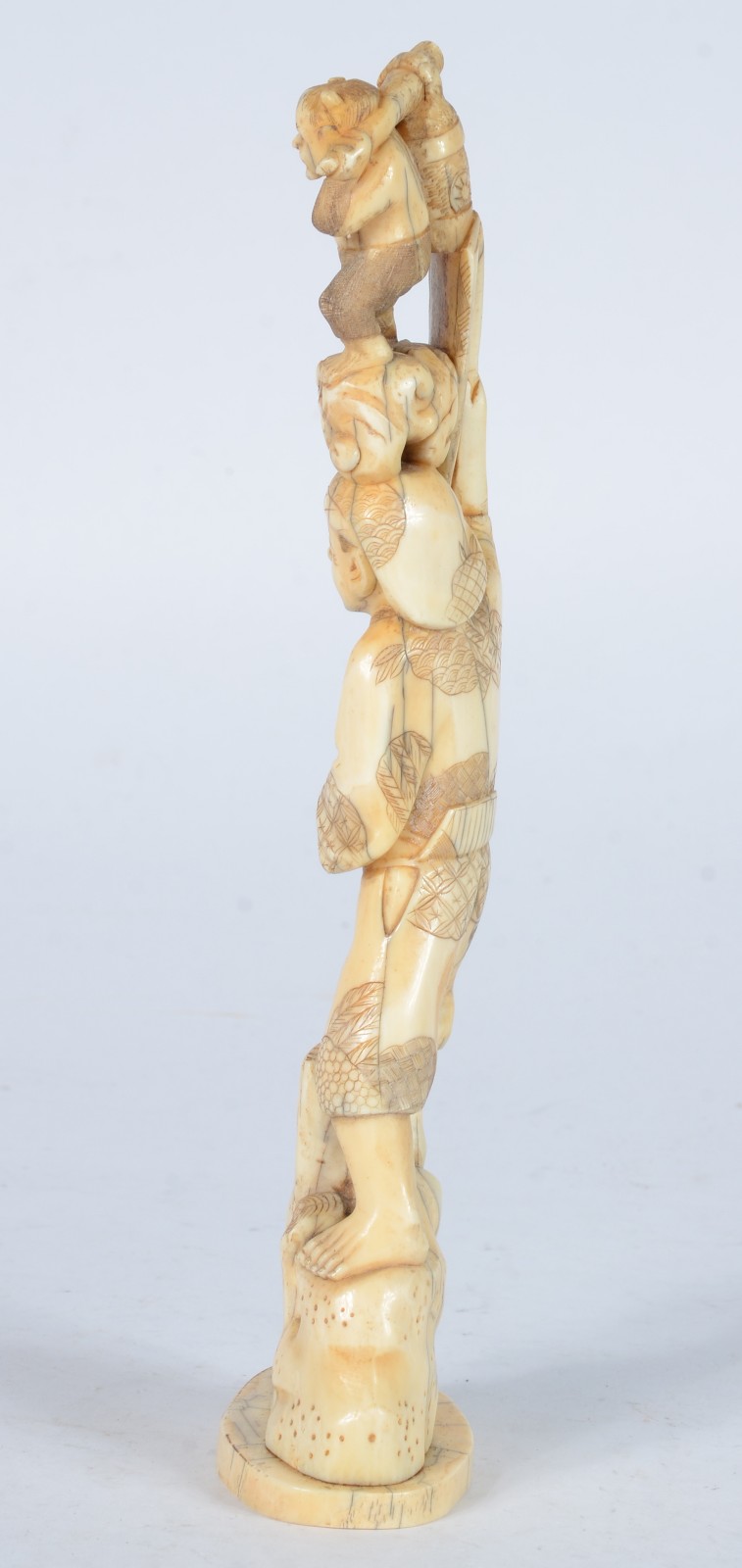 Escultura de marfim representando figura masculina segurando "homem". - foto 5 de 7
