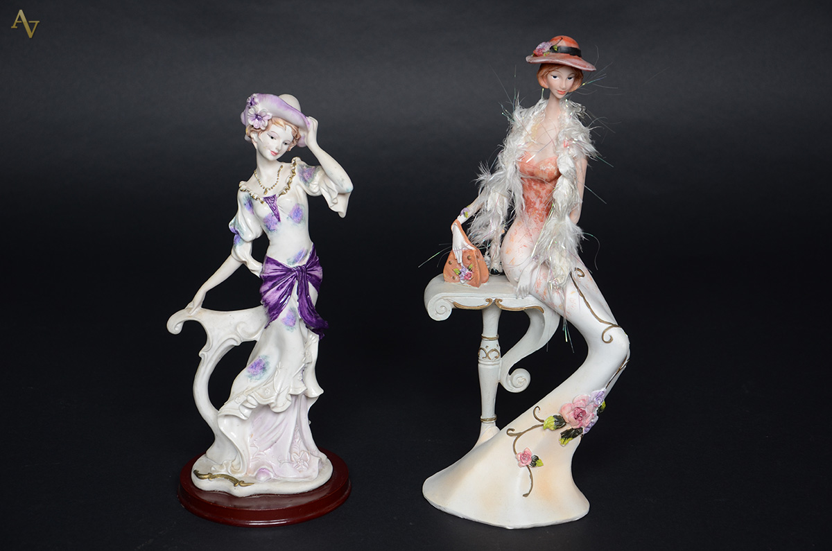 Duas esculturas de resina representando figuras femininas. Alturas 34...