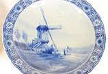 Par de medalhões de faiança holandesa de Delft,... - Par de medalhões de faiança holandesa de Delft, decoradas em tons de azul e branco com cenas de moinho e paisagem com casa, árvores e rio. Borda...