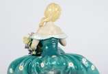 Estatueta de porcelana policromada representand... - Estatueta de porcelana policromada representando jovem com flores. Pétalas com lascados.