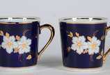 Par de xícaras de porcelana na cor azul cobalto... - Par de xícaras de porcelana na cor azul cobalto com flores em policromia.