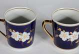 Par de xícaras de porcelana na cor azul cobalto... - Par de xícaras de porcelana na cor azul cobalto com flores em policromia.