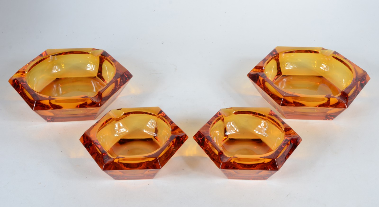 Conjunto com 4 cinzeiros de cristal âmbar facetados. - foto 1 de 5