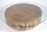 Mesa de centro com base na forma de "tronco" de... - Mesa de centro com base na forma de "tronco" de madeira, tampo de vidro.