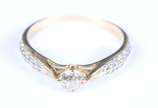 Anel solitário de ouro 18 k., brilhante central... - Anel solitário de ouro 18 k., brilhante central de aproximadamente 0,35 ct com brilhantes nas laterais. Aro 19/20. (Por motivos de segurança a p...