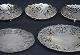Cinco pratos porta petiscos de metal prateado i... - Cinco pratos porta petiscos de metal prateado ingles MAPPIN WEBB, detalhes vazados, marcados na base. Diâmetros 15,5 cm à 26 cm.